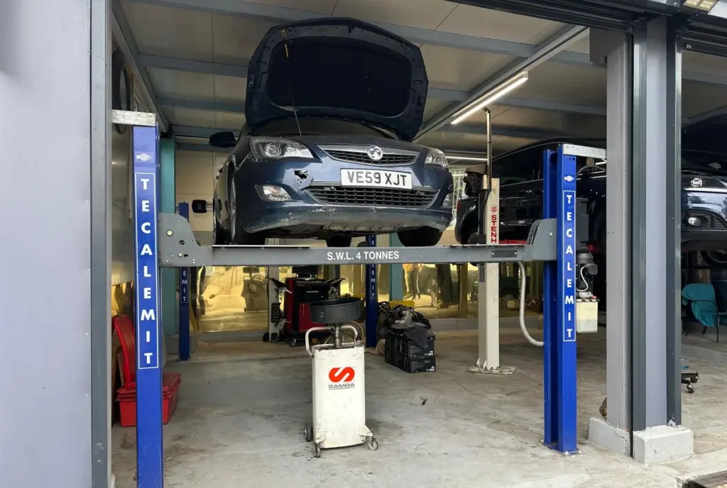 A car raised on the ramp at AMD Tyres in Colchester with the bonnet open