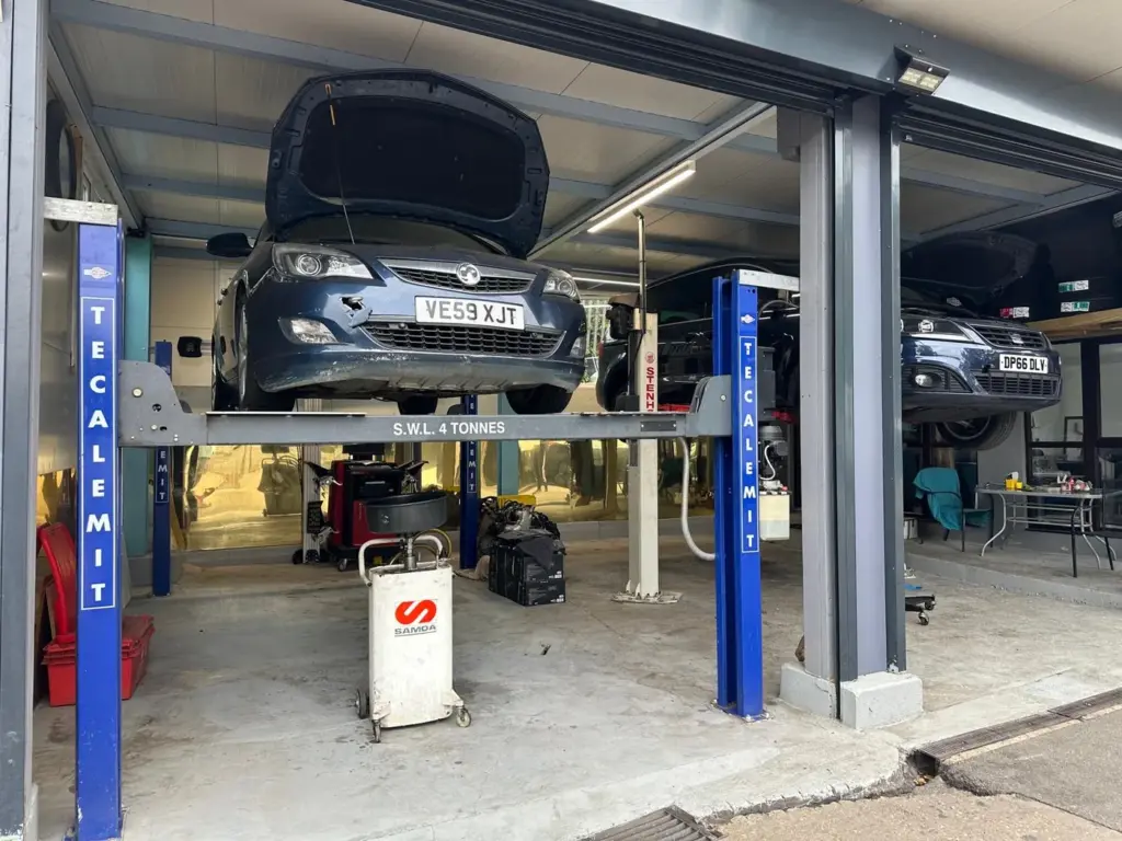 Both bays at AMD Tyres in Colchester, each with a car raised on a four tonne ramp