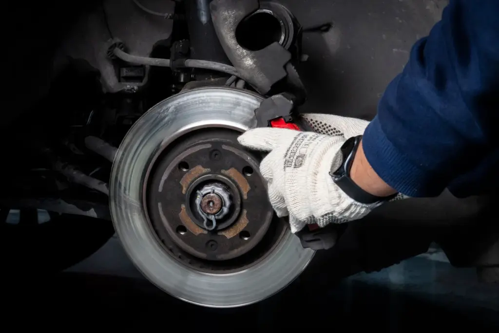A mechanic holding a brake disc taken off a car