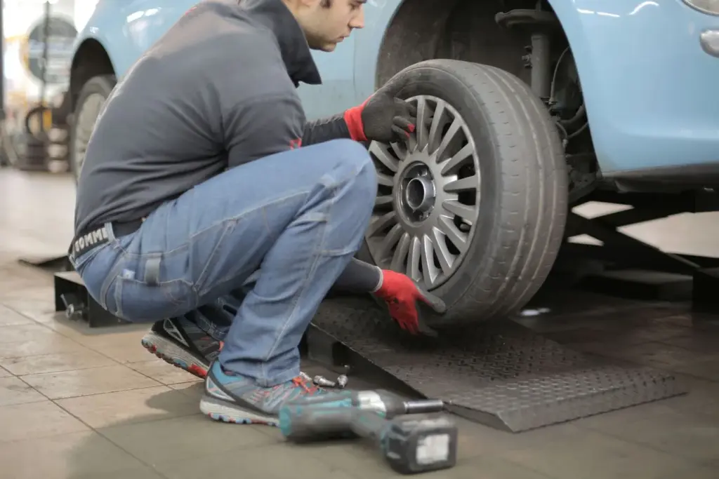 A mechanic fitting a tyre to a car wheel