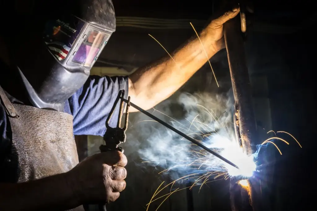 A welder working on metal, throwing sparks